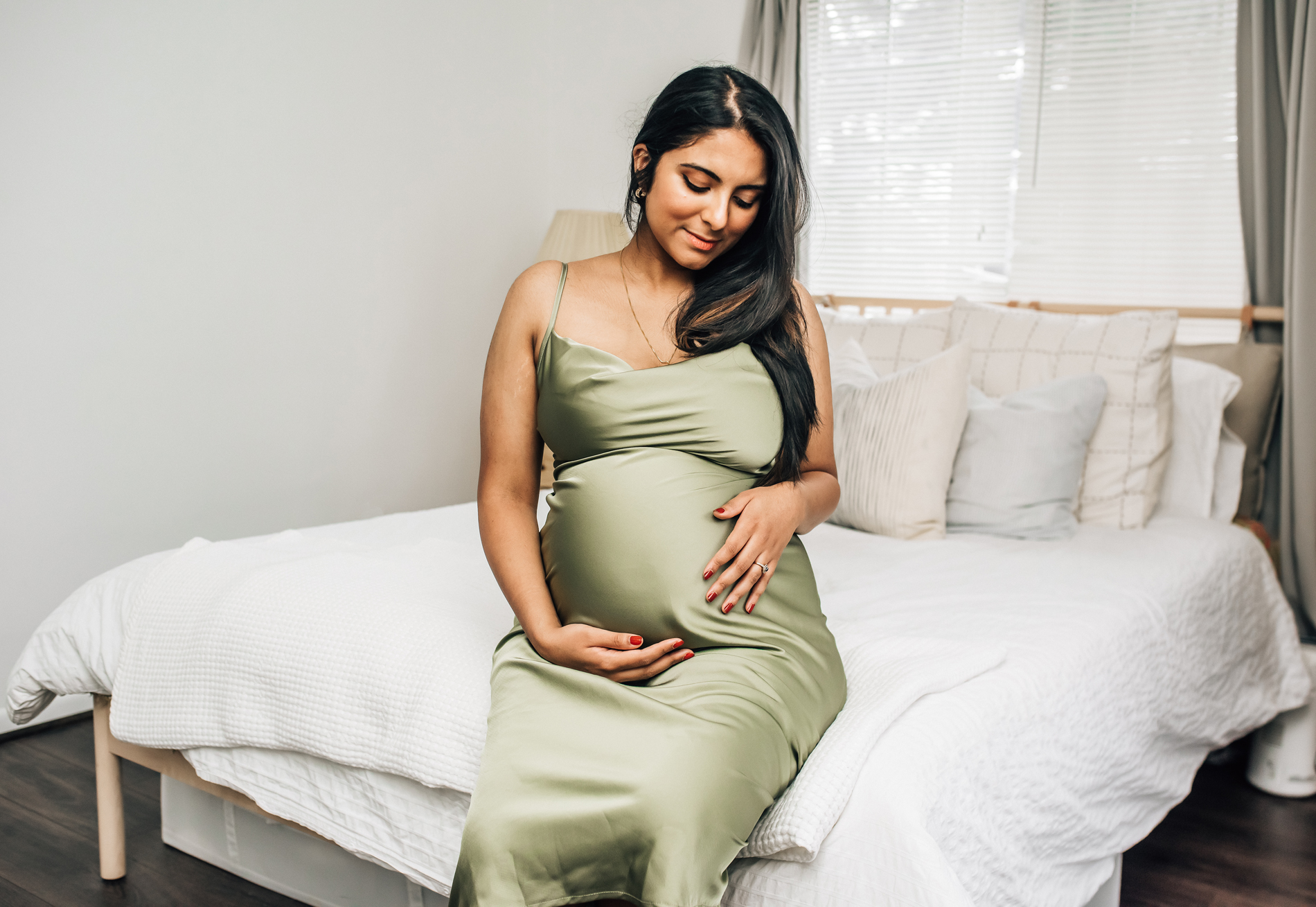 Maternity Photographer, An expectant mother sits at the end bed